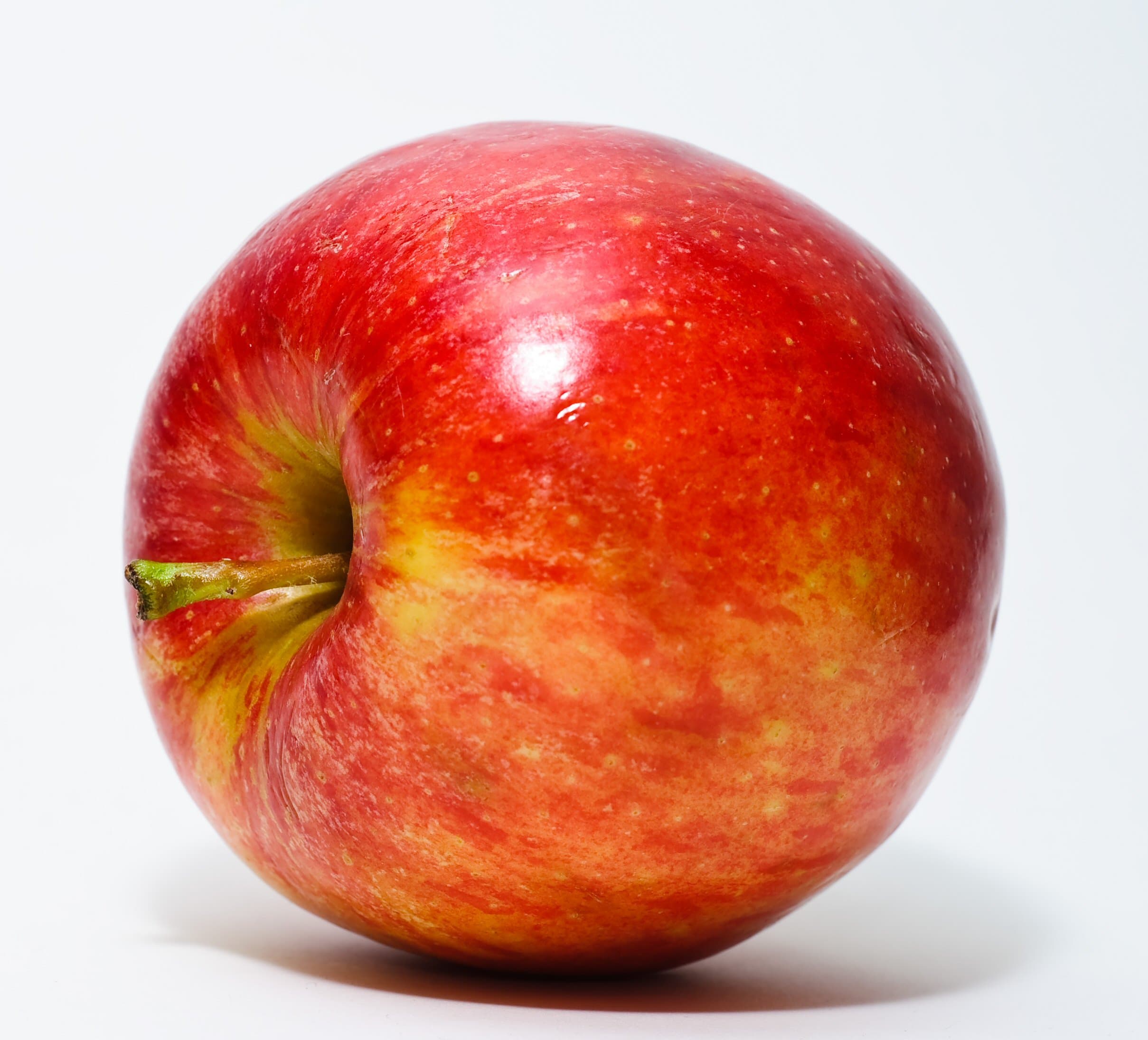 Roter, ungeschälter Apfel vor weißem Hintergrund